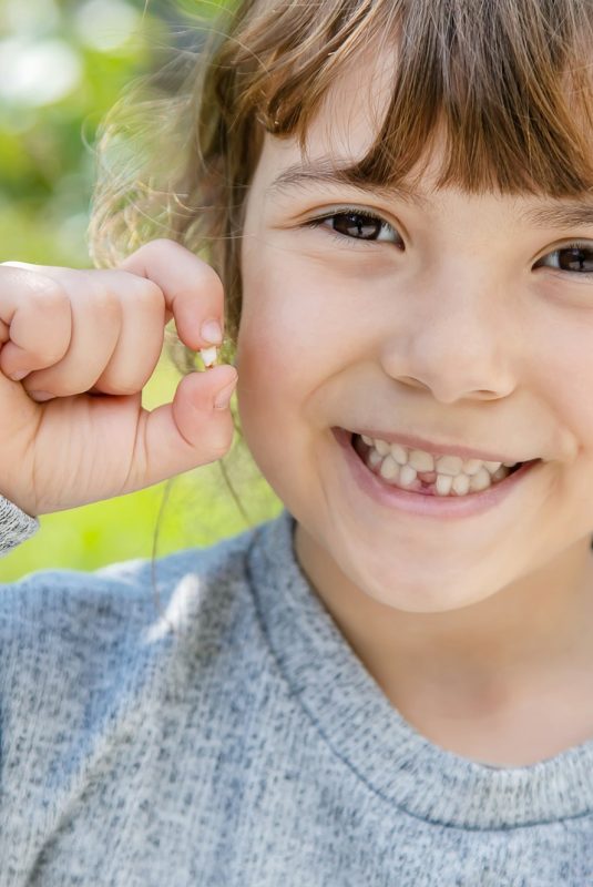 The kid had a baby tooth. Selective focus.